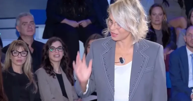 Maria De Filippi a C'è posta per te con giacca e pantaloni grigi